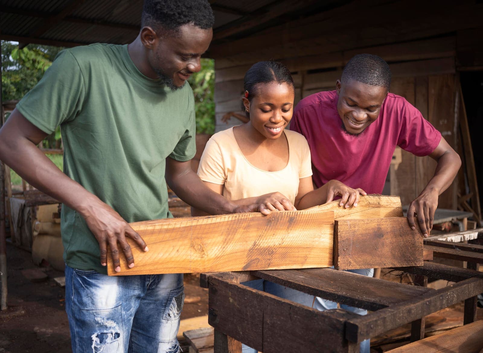 Three carpenters measuring wood in their workshop